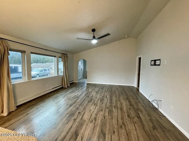 spare room featuring ceiling fan, dark hardwood / wood-style flooring, vaulted ceiling, and a baseboard heating unit