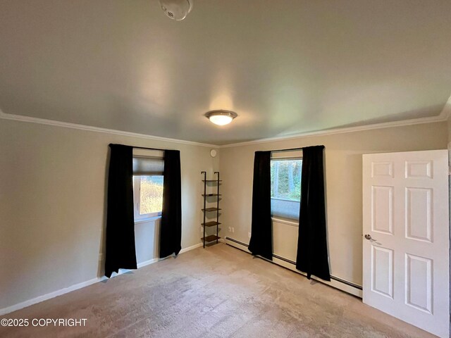 carpeted spare room with crown molding and baseboard heating