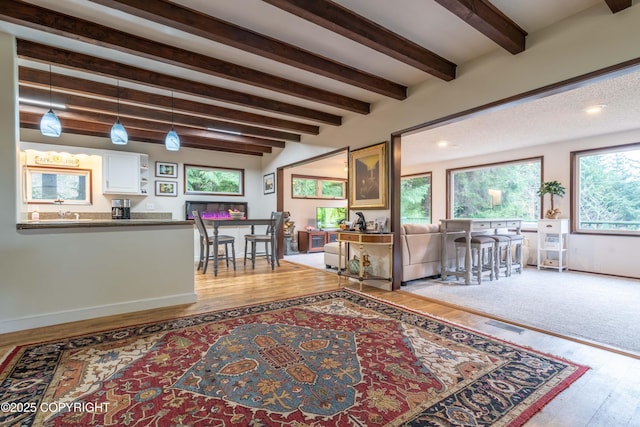 living room with light wood-type flooring and beamed ceiling