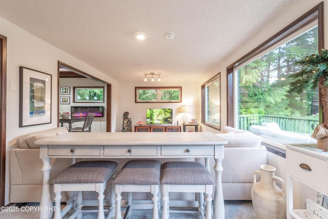 kitchen featuring a textured ceiling, a breakfast bar, and white cabinetry