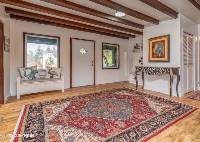 foyer entrance featuring light hardwood / wood-style floors and beamed ceiling