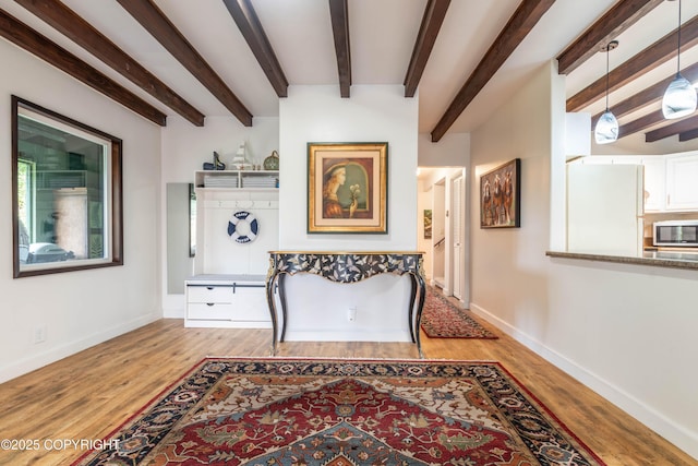 corridor with beam ceiling and light hardwood / wood-style flooring