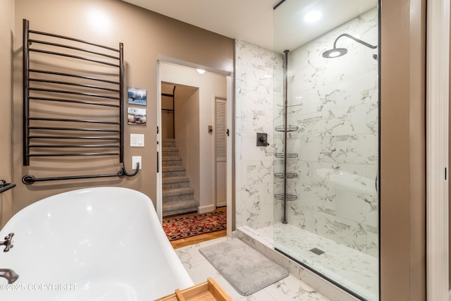 bathroom featuring shower with separate bathtub and radiator