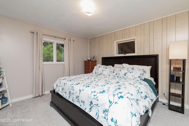 bedroom featuring wooden walls and light carpet