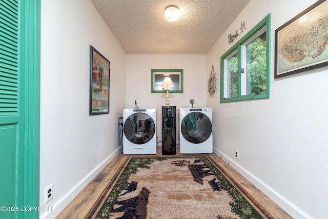 laundry area with independent washer and dryer, a textured ceiling, and hardwood / wood-style floors