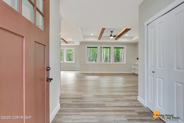 entryway featuring light wood-type flooring, ceiling fan, plenty of natural light, and beamed ceiling