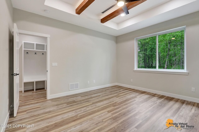 unfurnished bedroom featuring ceiling fan, beamed ceiling, and light hardwood / wood-style floors