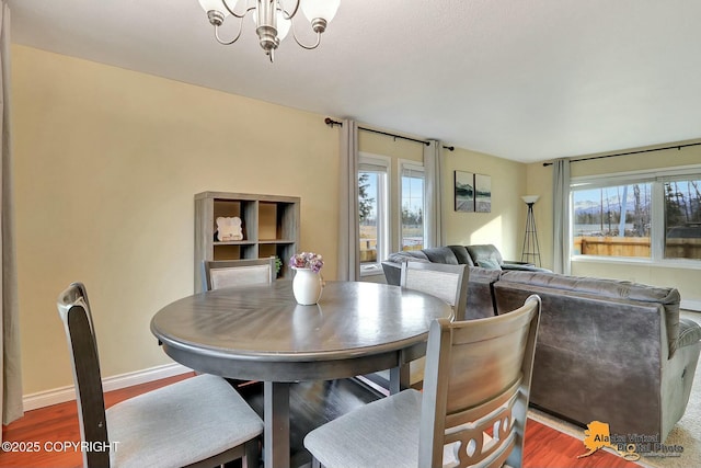 dining area with wood finished floors, baseboards, and a chandelier