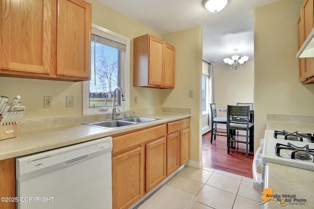 kitchen featuring a sink, white appliances, an inviting chandelier, light countertops, and light tile patterned floors