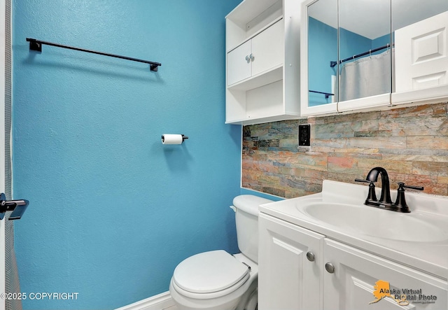 bathroom with baseboards, tasteful backsplash, vanity, and toilet