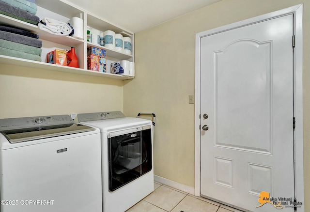 laundry area featuring baseboards, light tile patterned flooring, laundry area, and washer and clothes dryer