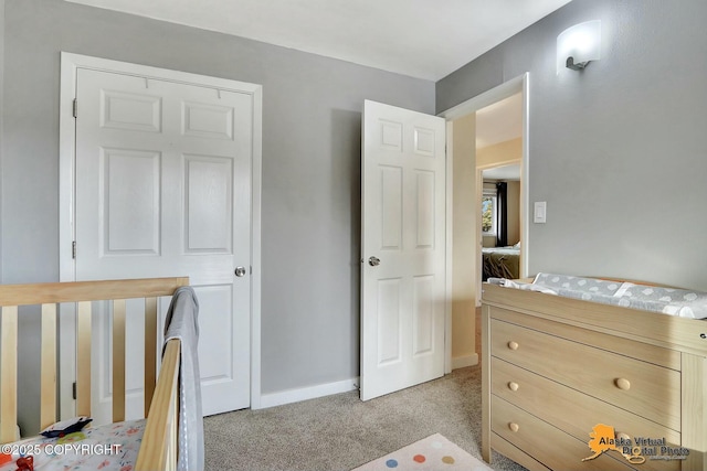 bedroom with baseboards and light colored carpet