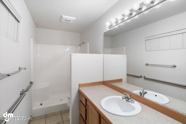 bathroom with a shower, toilet, vanity, and tile patterned flooring