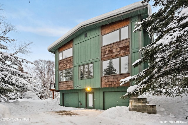 view of snow covered exterior with a garage