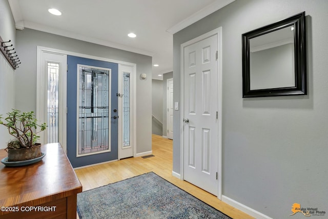 foyer entrance with crown molding, wood finished floors, and recessed lighting