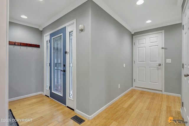 foyer featuring baseboards, light wood-style flooring, visible vents, and crown molding