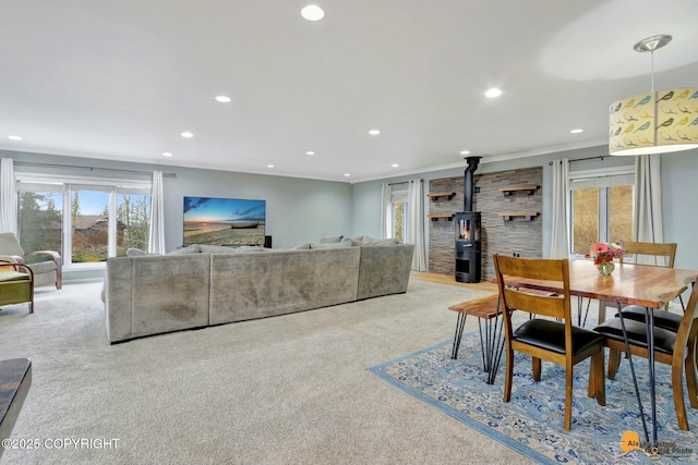 dining space with light carpet, ornamental molding, a wood stove, and recessed lighting