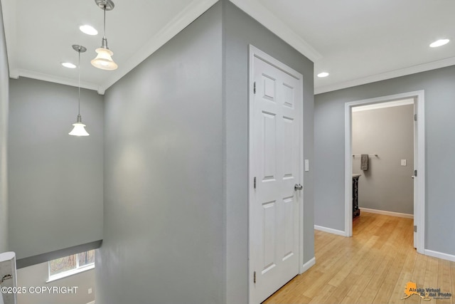 corridor with light wood-type flooring, crown molding, baseboards, and recessed lighting