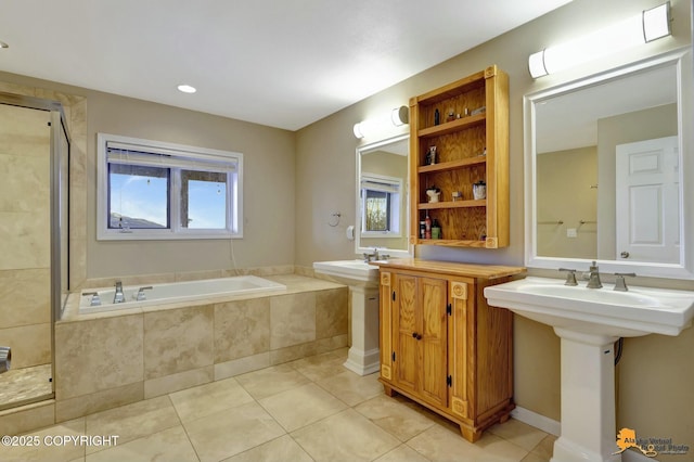 bathroom with a garden tub, tile patterned flooring, a tile shower, and a sink