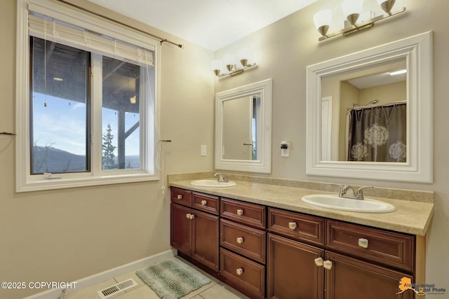 bathroom featuring double vanity, tile patterned flooring, a sink, and visible vents