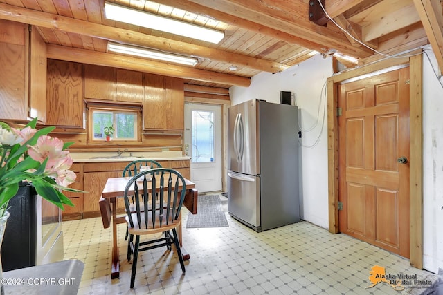 kitchen featuring sink, wood ceiling, stainless steel refrigerator, and beamed ceiling