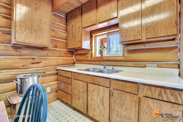 kitchen featuring log walls and sink