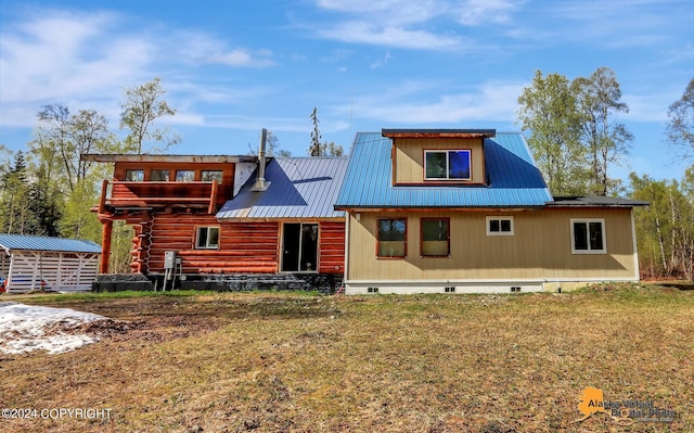 back of house featuring a storage unit and a yard