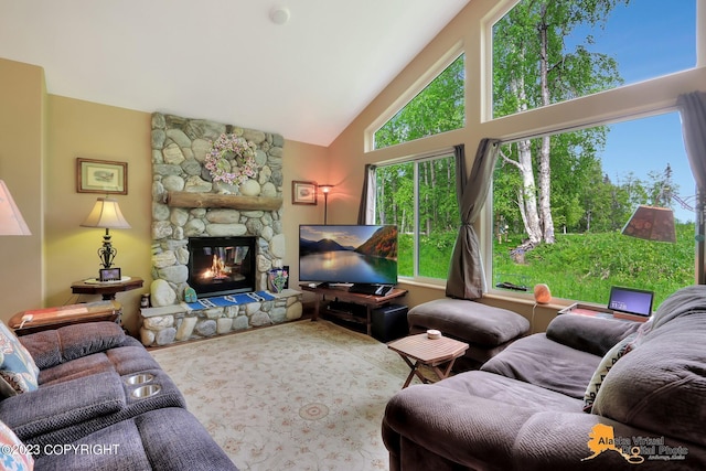 living room featuring a stone fireplace and high vaulted ceiling