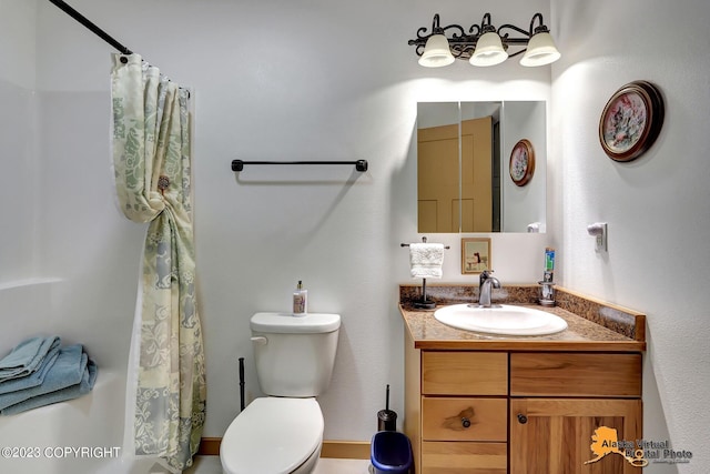 bathroom with toilet, vanity, and curtained shower