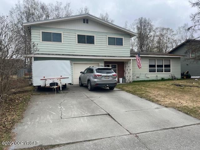 view of front of home with a garage, concrete driveway, and a front lawn