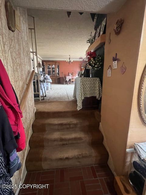 stairway with brick floor and a textured ceiling