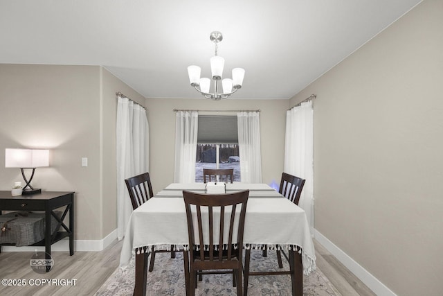 dining area featuring light hardwood / wood-style floors and a chandelier