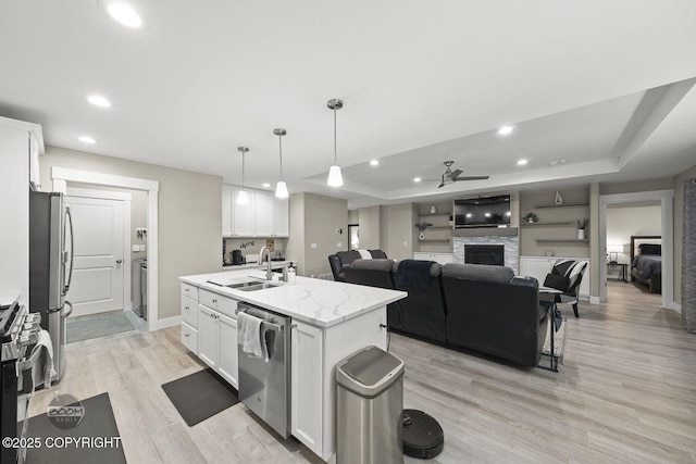 kitchen with white cabinetry and an island with sink