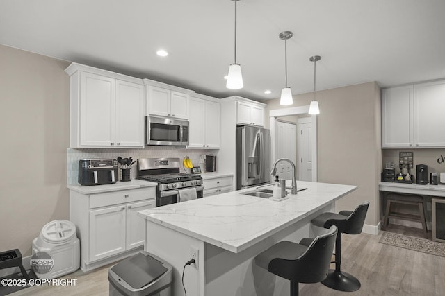 kitchen with sink, pendant lighting, white cabinetry, and appliances with stainless steel finishes