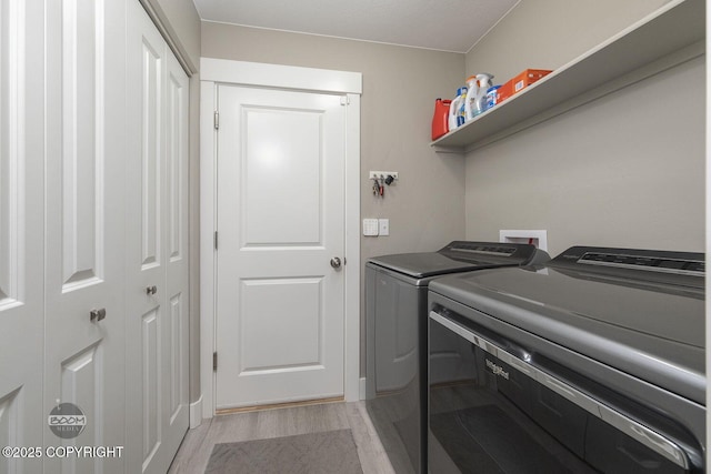 laundry room featuring light hardwood / wood-style floors and washer and dryer