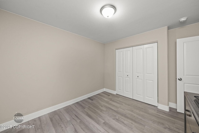 unfurnished bedroom with a closet and light wood-type flooring