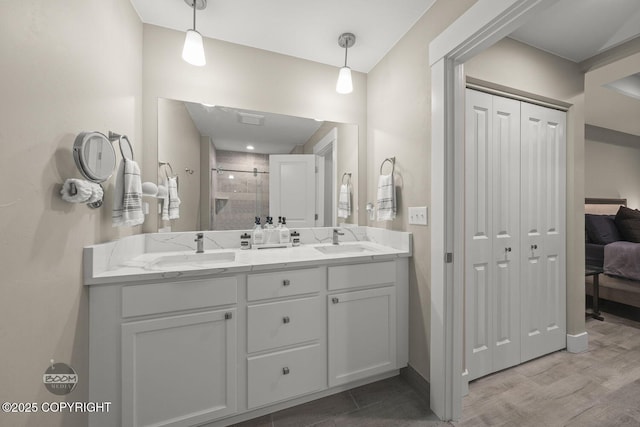 bathroom featuring hardwood / wood-style flooring, vanity, and a shower with door