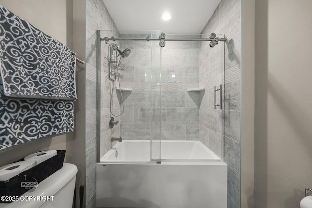 bathroom with toilet and shower / bath combination with glass door