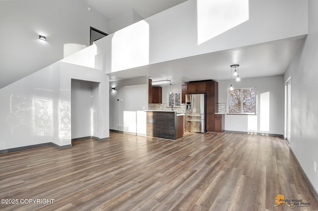 unfurnished living room with dark hardwood / wood-style flooring and a high ceiling