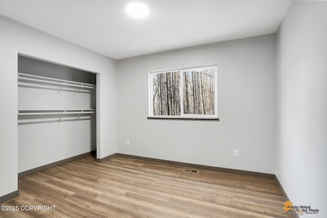 unfurnished bedroom with hardwood / wood-style floors and a closet