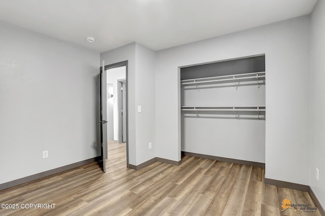 unfurnished bedroom with light hardwood / wood-style floors and a closet