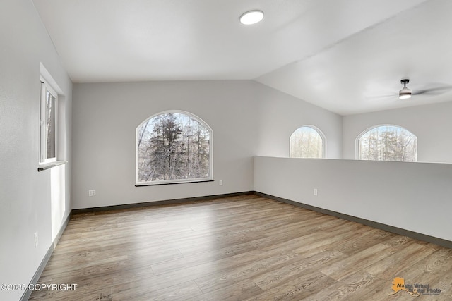 spare room featuring vaulted ceiling, light hardwood / wood-style floors, and ceiling fan