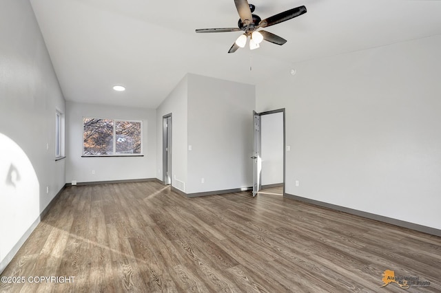 empty room with hardwood / wood-style flooring, lofted ceiling, and ceiling fan