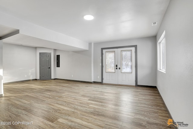 entrance foyer featuring french doors, electric panel, and light hardwood / wood-style flooring