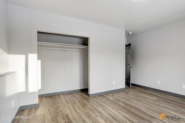 unfurnished bedroom featuring light hardwood / wood-style floors and a closet