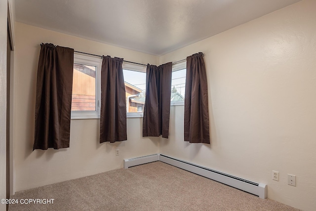 carpeted spare room featuring a baseboard radiator