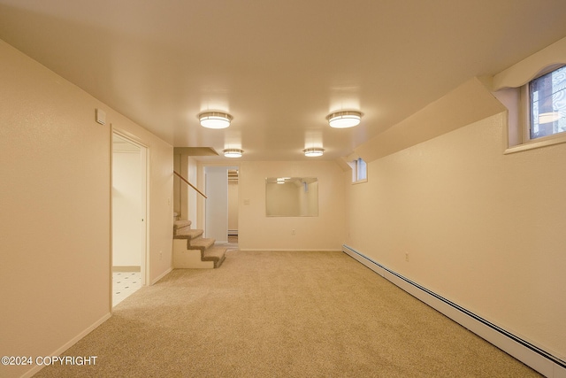 basement featuring light colored carpet and a baseboard heating unit