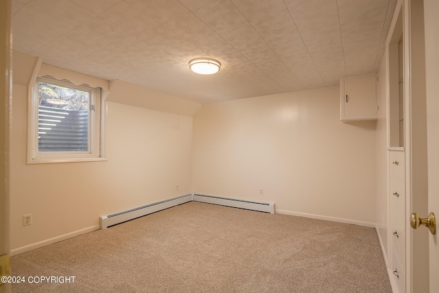 spare room with light colored carpet, lofted ceiling, and a baseboard heating unit