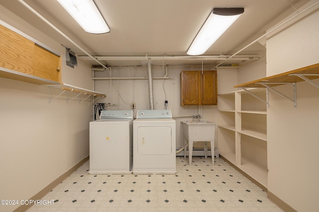 laundry area featuring cabinets, independent washer and dryer, sink, and a baseboard heating unit