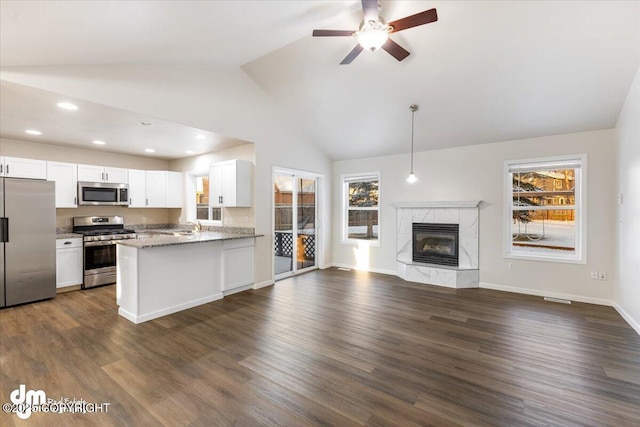 kitchen with white cabinetry, light stone counters, kitchen peninsula, and appliances with stainless steel finishes